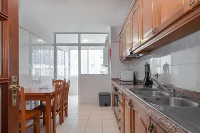 a kitchen with a sink and a table with chairs at Piornais by Homie in Funchal