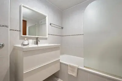 a white bathroom with a sink and a bath tub at Piornais by Homie in Funchal