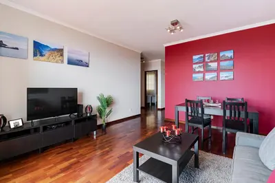 a living room with a red accent wall at Caniço V by An Island Apart in Caniço
