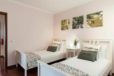 two beds in a room with white walls at Caniço V by An Island Apart in Caniço
