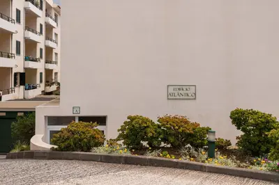 a white building with a sign on the side of it at Caniço V by An Island Apart in Caniço