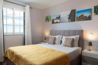 a bedroom with a large bed and a window at Caniço V by An Island Apart in Caniço