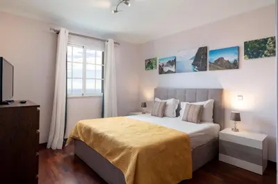 a bedroom with a large bed and a window at Caniço V by An Island Apart in Caniço
