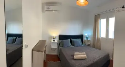a small bedroom with two beds and a window at Casa do Arco in Arco da Calheta