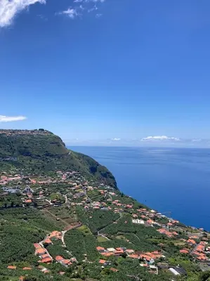 an island with houses on a hill next to the water at Casa do Arco in Arco da Calheta