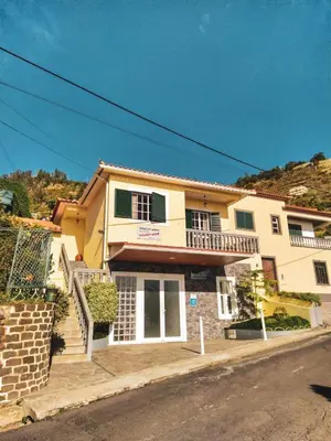 a large yellow house with stairs and windows at Casa do Arco in Arco da Calheta