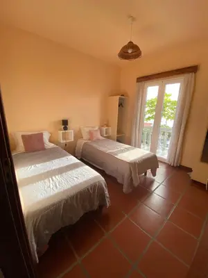 a bedroom with two beds and a window at Casa do Arco in Arco da Calheta