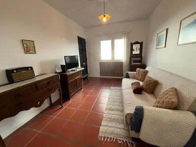 a living room with a couch and a tv at Casa do Arco in Arco da Calheta