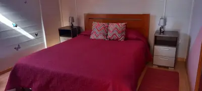 a bedroom with a large bed with a purple blanket at Top view in Ponta do Sol