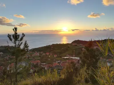 a sunset over a small town on a hill at Top view in Ponta do Sol