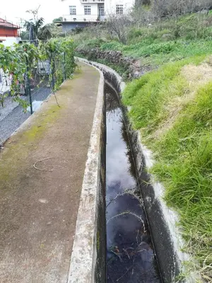 a small channel of water in a field at Top view in Ponta do Sol