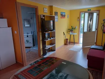 a living room with yellow walls and a table at Top view in Ponta do Sol