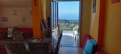 a living room with a sliding glass door to a balcony at Top view in Ponta do Sol