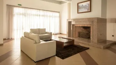 a living room with a couch and a fireplace at Hotel Santa Maria in Vila do Porto