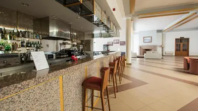 a bar with a row of stools at Hotel Santa Maria in Vila do Porto