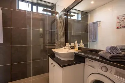 a bathroom with a washing machine and a sink at Atlantic Pearl America apartment by Holiday Rental Madeira in Funchal