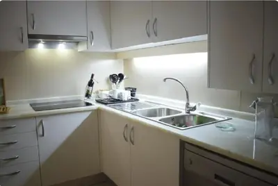 a kitchen with white cabinets and a sink at Un Balcon Sur La Mer in Funchal