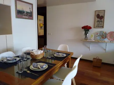a dining room with a table and white chairs at Un Balcon Sur La Mer in Funchal
