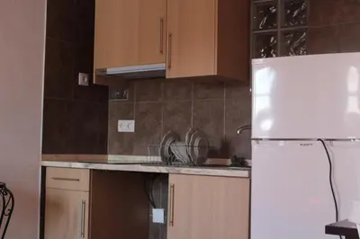 a kitchen with wooden cabinets and a white refrigerator at Casa Marreiros Holiday Home in Vila do Bispo