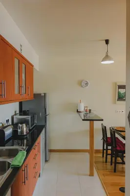 a kitchen with wooden cabinets and a table in it at Sunrise House in Ponta Delgada