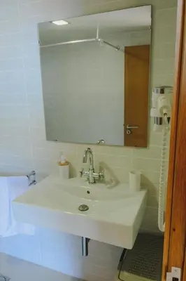 a bathroom with a sink and a mirror at Sunrise House in Ponta Delgada