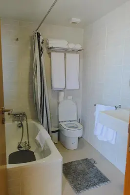 a bathroom with a tub and a toilet and towels at Sunrise House in Ponta Delgada