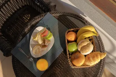 a table with a basket of fruit and a plate of bread at Pool Villa with Botanical Garden in Funchal