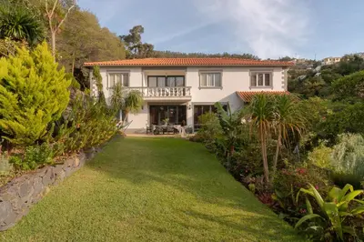 a large white house with a yard with plants at Pool Villa with Botanical Garden in Funchal