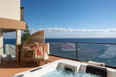 a hot tub on a balcony with a view of the ocean at Baía I by An Island Apart in Funchal