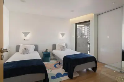 two beds in a room with a window at Baía I by An Island Apart in Funchal