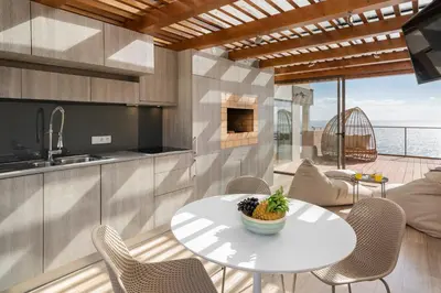 a kitchen and dining room with a table and chairs at Baía I by An Island Apart in Funchal