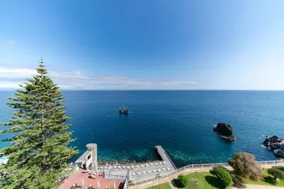 an island in the ocean with a boat in the water at Baía I by An Island Apart in Funchal