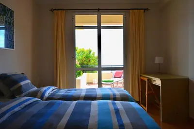 a bedroom with a bed and a sliding glass door at Jardim do Arco 