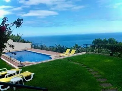 a swimming pool with a view of the ocean at Jardim do Arco 