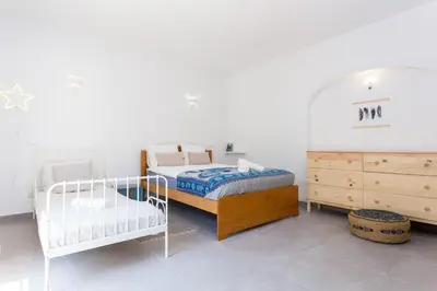 a white bedroom with two beds and a dresser at Quinta da Liberdade in Luz
