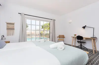 a bedroom with two white beds and a window at Quinta da Liberdade in Luz