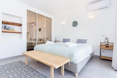 a white bedroom with a bed and a wooden bench at Quinta da Liberdade in Luz