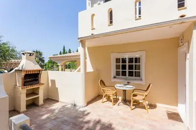 a patio of a house with a table and chairs at Quinta da Liberdade in Luz