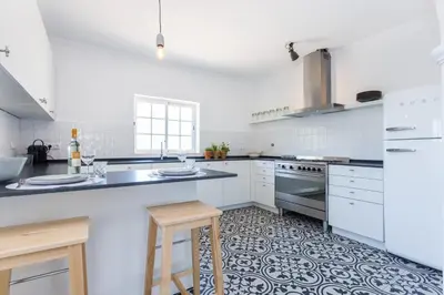 a kitchen with white cabinets and a stove top oven at Quinta da Liberdade in Luz