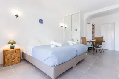 a white bedroom with a bed and a table at Quinta da Liberdade in Luz