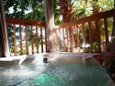 a hot tub on a porch with a wooden deck at Casas Serenas in Estreito da Calheta