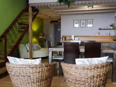 a dining room with a table and chairs and a staircase at Casas Serenas in Estreito da Calheta