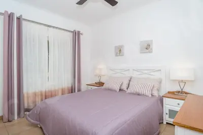 a white bedroom with a bed and a window at Casa Clajon in Budens