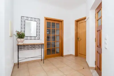 a hallway with a table with a mirror and a door at Casa Clajon in Budens