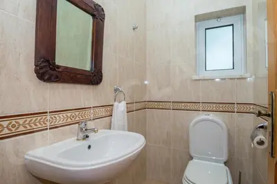 a bathroom with a sink and a toilet and a mirror at Casa Clajon in Budens