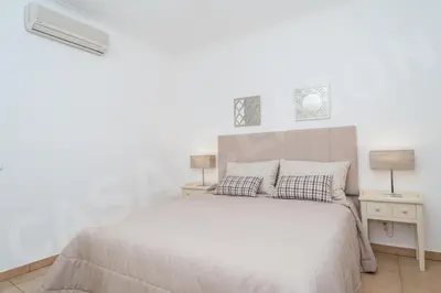 a white bedroom with a bed and two lamps at Casa Clajon in Budens