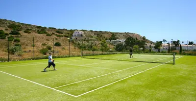 two people playing tennis on a tennis court at Luz Beach Luxury Apartment in Luz