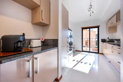 a kitchen with white cabinets and a counter top at Luz Beach Luxury Apartment in Luz
