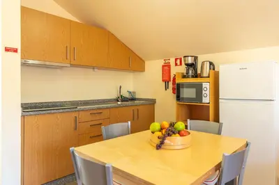 a kitchen with a table with a bowl of fruit on it at Quinta Frizado in Prazeres
