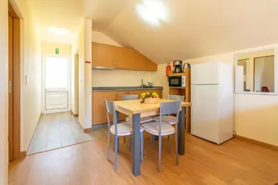 a kitchen with a table and chairs and a refrigerator at Quinta Frizado in Prazeres